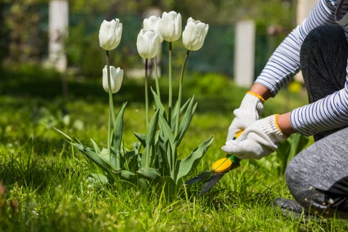 Technician using powered garden machinery with protective gear