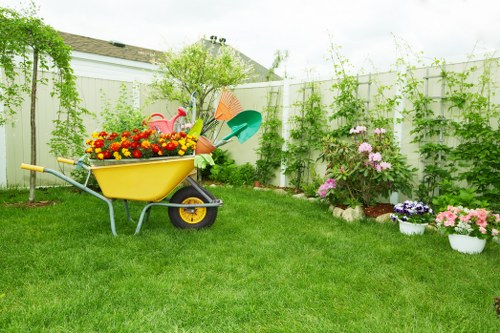 Gardening team carrying materials through a mews house entrance with restricted access